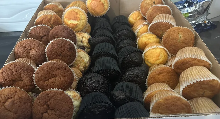 A box packed with assorted chocolate, blueberry and corn muffins
