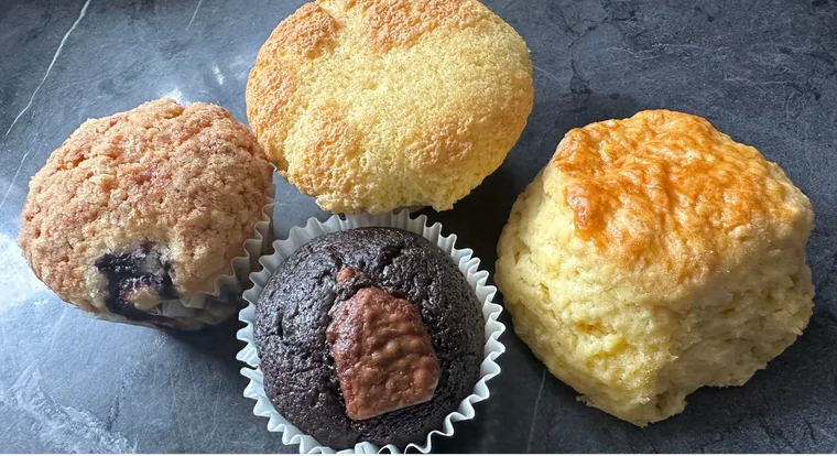 A blueberry muffin, chocolate muffin, corn muffin and a golden scone