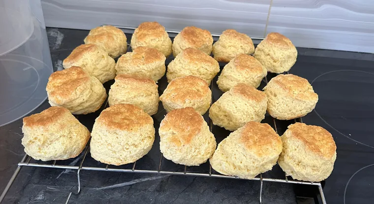 Rows of freshly baked golden scones cooling on a wire rack